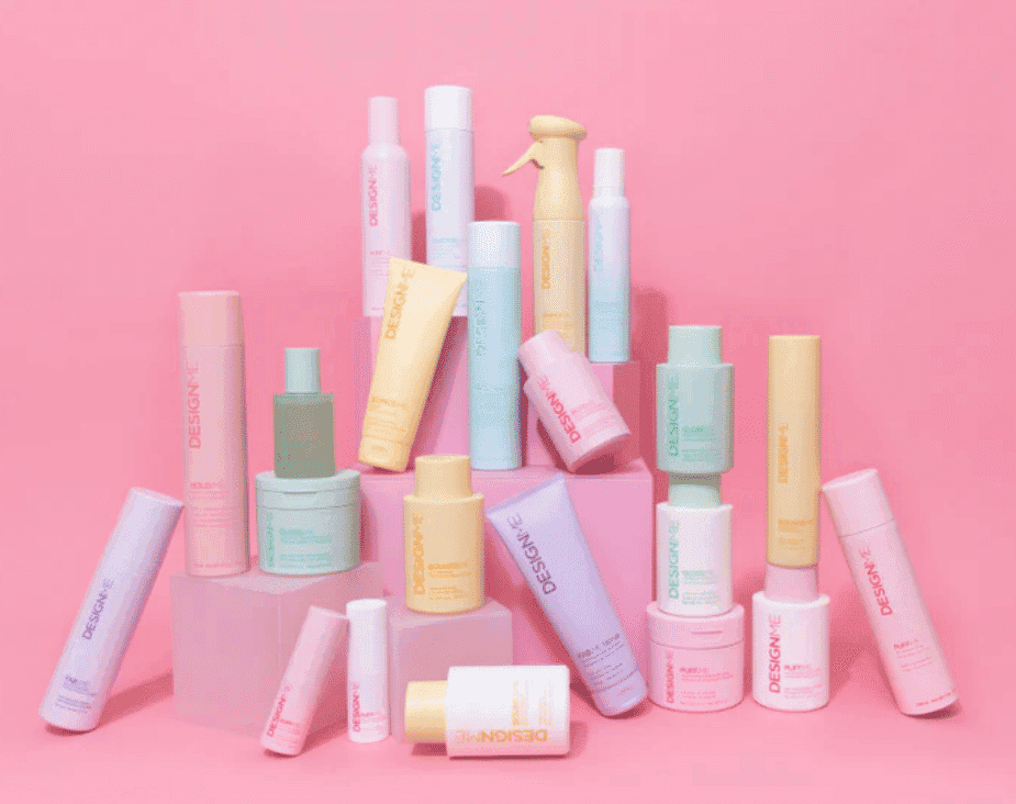 Arrangement of pastel-colored skincare products on a pink background.